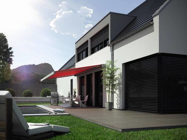 Modernes Einfamilienhaus mit Terrasse, Markise, Gartenmöbeln und gepflegtem Rasen.